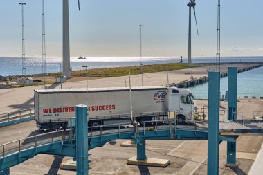 Trelleborg, İsveç; 23 Eylül 2025: Perde kenarı römorklu beyaz Mercedes-Benz TVG Grup kamyonu liman terminalindeki vapura doğru gidiyor..