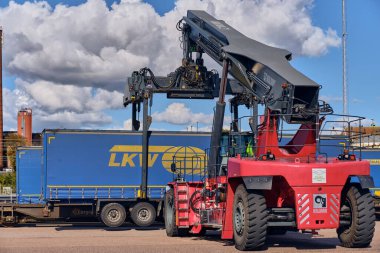 Trelleborg, İsveç; 23 Eylül 2025: Kalmar Reachstacker, Walter LKW karavanını Trelleborg feribot limanına yüklüyor, İsveç.