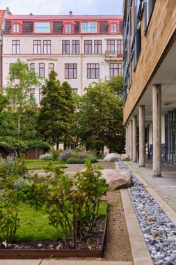 Helsingborg, Sweden ; August 12, 2025: Landscaped courtyard with greenery and modern residential architecture illustrating sustainable urban development and contemporary living.