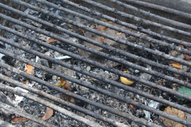 Izgara ızgaraları yeni bitmiş bir barbekü olayına işaret ediyor. Küller ve molozlar etrafa saçılmış..