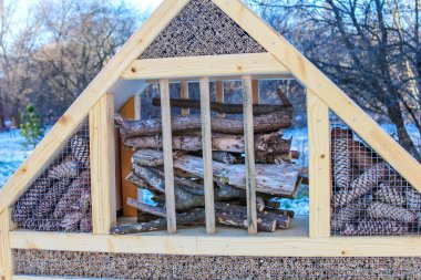 Eşsiz bir yapı, karlı bir manzaranın ortasında rahat bir depolama alanı sağlayan düzgün istiflenmiş ahşap kütükleri gösterir..