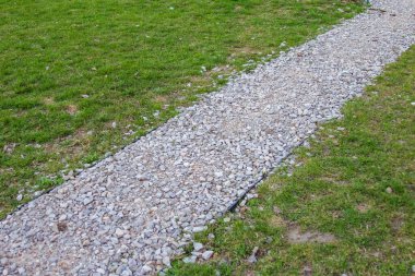 Park 'ta Yeşil Çimenler Arasında Çakıl Yolu Yürüyen Yol ve Çim Arasında Doğal Bölünme Oluşturuyor