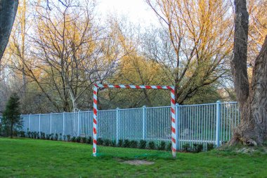 Beyaz Metal Çitleri ve Kırmızı ve Beyaz Güvenlik Bariyeri ile Park Alanı Sonbahar Alanında Spor Alanında Sınır Oluşturdu