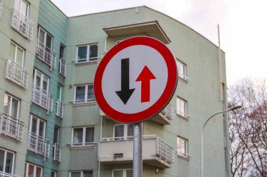 Kırmızı ve Mavi Yol İşareti, Dar Sokak 'ta, Apartman Binası' nın yanında çift yönlü trafik olduğunu gösteriyor.
