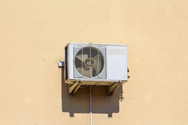 Beyaz Havalandırma Ünitesi Güneşli Hava 'da Bej Bina Dış Duvarına Bağlandı