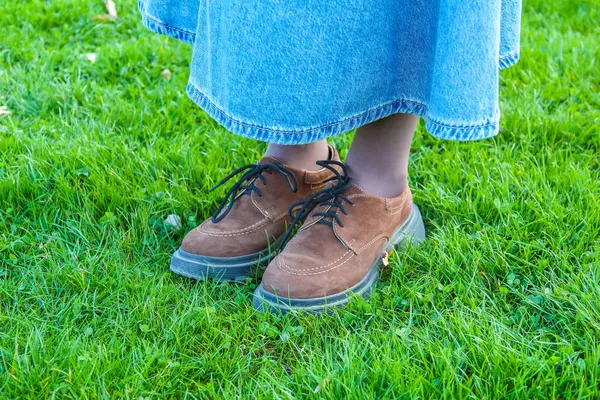 Günlük Kahverengi Deri Oxford Ayakkabılar Canlı Yeşil Bahar Çimenlerinde Mavi Kot ile