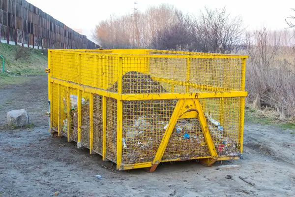 Kırsal Atık Toplama İçin Parlak Sarı Metal Kafes ya da Kapatma Kırsal Arazide Toprak Toprakta Duruyor