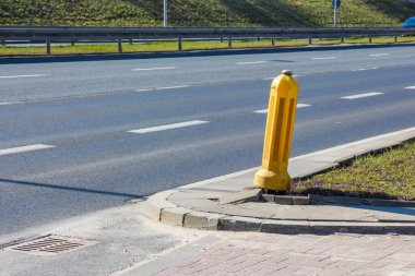 Beton Trafik Adası yakınlarındaki Parlak Sarı Yol Güvenliği Bollard 'ın yakın görüntüsü