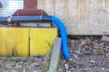 Sarı Duvara Karşı Mavi Metal Su Borusu ve Konut Binasının Beton Üssü