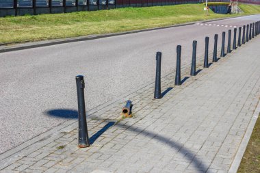 Paved Yolu 'ndaki Black Metal Bollards Sırası Tuğla Yüzey' de Gölge Düzeni Oluşturuyor