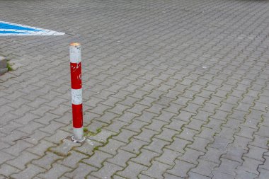 Çakıl Taşı Otoparkında Kırmızı ve Beyaz Çizgili Trafik Direği Güvenlik Bariyeri Oluşturuyor