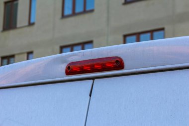 Şehir merkezinde park halindeki beyaz servis arabasının acil durum aracı fren lambası detayı