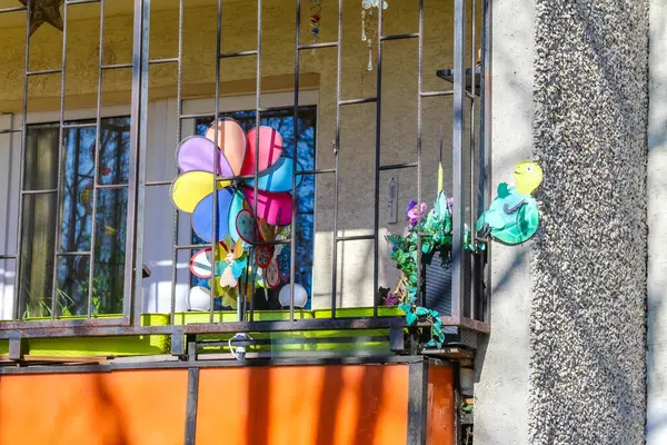 Renkli Fırıldak ve Yapay Çiçekler Ahşap Çitlere Karşı Balkon Korkuluğu Dekorasyonu