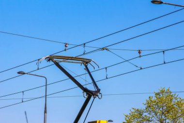 Elektrik Treni Pantografı Ağaç Yeşilliği ile Mavi Gökyüzüne Karşı Kablolara Bağlandı