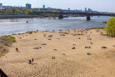 Şehir Plajı Sunbathers ile Nehir Kıyısı boyunca City Skyline ve Arkaplanda Köprü