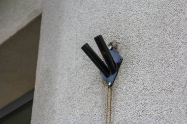 Elektrik Kablolarını Düzenlemek İçin Bej Dış Duvara Siyah Kablo Yönetimi Klipsi Bağlandı