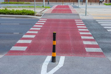 Şehir Kırmızı Bisiklet Yolu Beyaz Yol İşaretleri ve Güvenlik Bollard ile Şehir Caddesinde