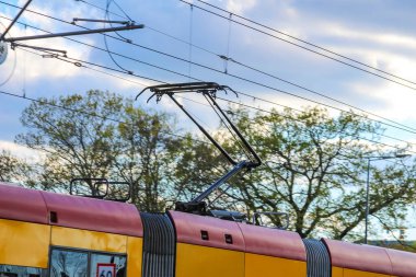 Elektrik Hatları ve Mavi Gökyüzüne Karşı Pantograf ile Elektrik Tramvayı Kentsel Ayarlarda Bahar Ağaçları
