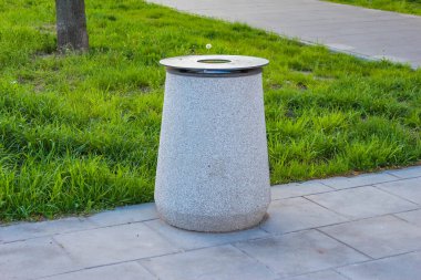 Şehir Kaldırımında Yeşil Çimlere Karşı Temiz Tasarımlı Minimalist Beton Çöp Kutusu