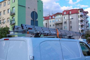 Konut Mahallesindeki Renkli Apartman Binaları 'nın önüne park edilmiş Çatı Raflı Servis Araçları