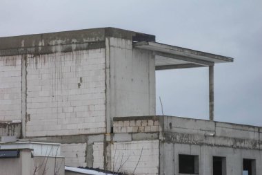 Terk Edilmiş Beton İnşaat Çerçevesi Yapısal Sütunları ve Bulutlu Gökyüzüne Karşı Bitmemiş İnşaatı Gösteriyor