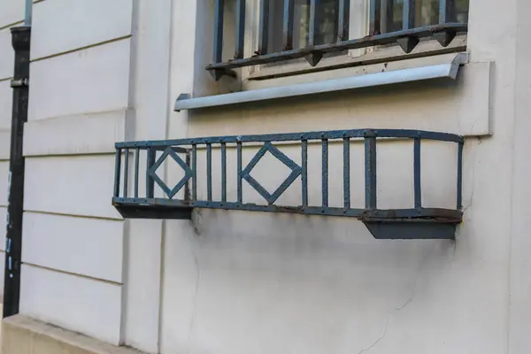 Klasik Avrupa binası cephesinde geometrik elmas desenli zarif işlenmiş demir balkon korkulukları.