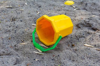 Yeşil saplı sarı plastik Kum Küflü Oyuncak Çocuk parkında Kum Yüzeyi Terk Edildi