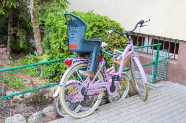 Şehir Bahçesi Atmosferi ile Yeşil Binanın Dışına park edilmiş Renkli Eski Bisikletler