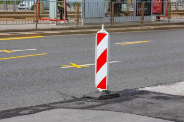 Asfalt Yolu 'nda kırmızı ve beyaz çizgili trafik bollard İnşaat Bölgesi için sarı şeritli işaretler