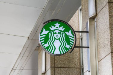 Modern Bej Bina Dış Duvarındaki Starbucks Kahve Logosu Tabelasına yakın çekim