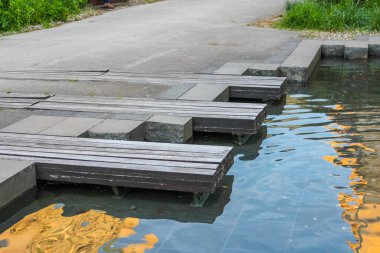 Yansıtıcı Su Yüzeyi Üzerine Minimalist Ahşap Platformlar Şehir Parkı 'nda Altın Işık Yakalıyor