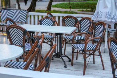 Örgü Sandalyeleri ve Şehir Merkezinde Beyaz Masaları olan Zarif Açık Cafe Terası