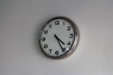 Tarafsız Arkaplan Karşısında Beyaz Yüzlü Siyah Rakamlı Basit Yuvarlak Duvar Saati