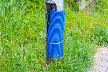 Mavi Plastik Boru Yeşil Çimen Alanından Doğal Ayar 'ın yakınındaki Footpath' den çıkıyor