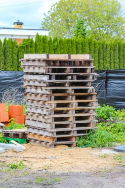 Açık İnşaat Alanında Yeşil Çit Arkaplanlı Ahşap Paletler Yığını