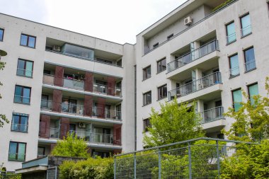 Balkonları ve Tan cephesi Kentsel Konut Alanında Ağaçlarla çevrili Modern Apartman Binası