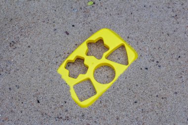 Gri Beton Yüzeyde Yıldızlı Sarı Plastik Kum Küfü ve Geometrik Şekiller