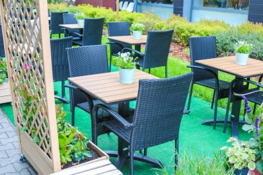 Yeşil Yapay Çimenli Açık Restoran Terası ve Modern Kara Yemek Mobilyaları