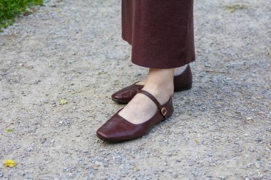Çakıl yolunda aynı eteği giyen Burgundy Mary Jane Deri Ayakkabı Giyen Kadın