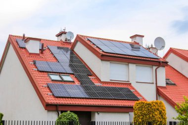 Kırmızı kiremit çatılı modern konut evleri banliyölerde yenilenebilir enerji yakalıyorlar.