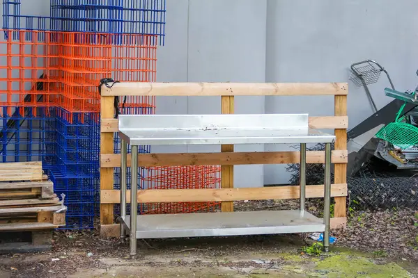 Açık Hava Atölyesi Ortamı 'nda Renkli Güvenlik Ağı Arkaplanı ile Metal Depolama Rafı İnşaatı