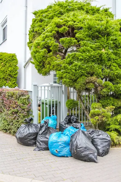 Siyah Çöp Torbaları Asfaltaya Sıralanmış Yeşil Tophane ve Beyaz Kapı