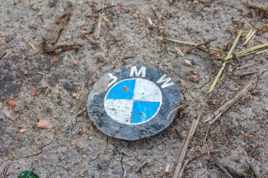 Yıpranmış taş yüzeyine gömülü mavi ve beyaz BMW logosu marka tanıma ayrıntıları yaratıyor