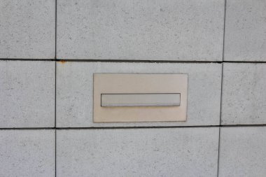 Gömülü posta yuvasına sahip modern gri beton kiremitler geometrik mimari detay deseni oluşturur