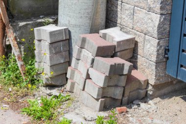 İnşaat alanında depolanan beton kaldırım taşı ve inşaat malzemeleri yığını.