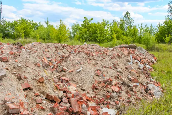 Bulutlu gökyüzünün altında yeşil ağaçlı ve kırsal manzaralı uzak inşaat enkazı manzarası