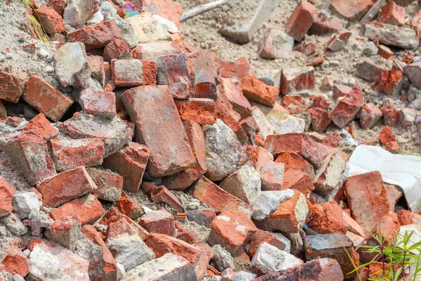 İnşaat alanı temizleme alanında büyük miktarda kırmızı tuğla ve beton yıkım enkazı birikmiş.