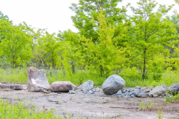 Yeşil arazi kireçtaşı yapı malzemeleri ve taş blokları ile doğal taş ocağında çimenlik araziye saçıldı.