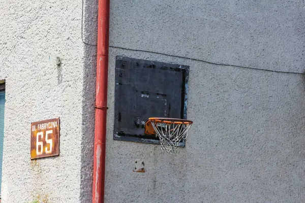 Kırmızı çerçeveli gri beton duvar. 55 adres işareti ve küçük pencere açılıyor.