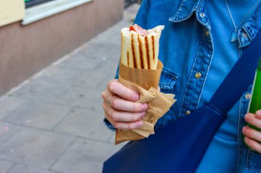Mavi ceketli biri, elinde altın ballı ahşap ballı Dipper tutuyor. Gün ışığında dışarıya damlıyor.